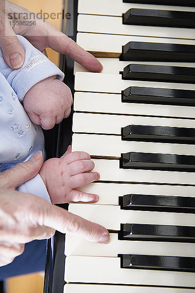 Nahaufnahme der Hände auf einer Klaviertastatur.