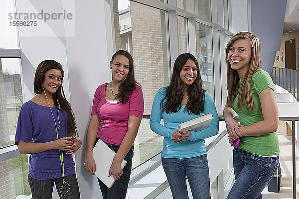 Lächelnde Teenager-Mädchen auf dem Flur der Hochschule