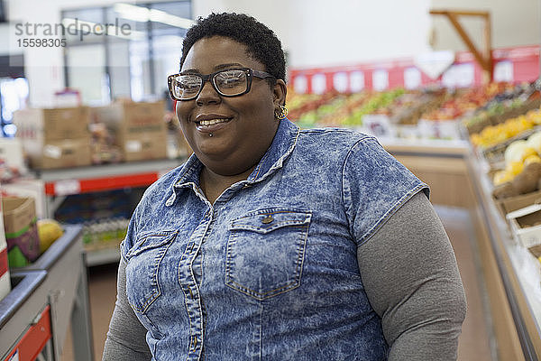 Porträt einer glücklichen Frau mit bipolarer Störung beim Einkaufen im Supermarkt
