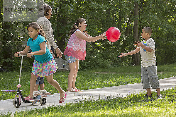 Hispanische Familie spielt mit autistischem Jungen im Park