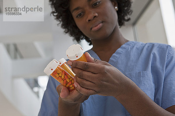 Jamaikanische Krankenschwester kontrolliert Pillenflaschen