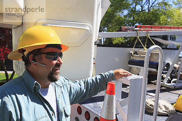 Energietechniker mit Hubkübelwagen bei Arbeiten an Stromleitungen