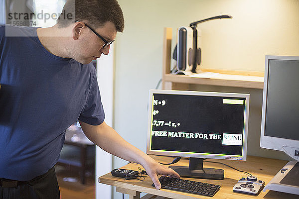 Mann mit Sehbehinderung an seinem Computer