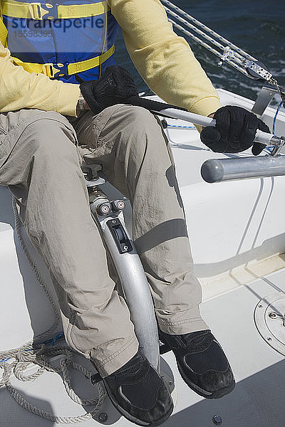 Behinderter Mann  der ein Boot steuert  niedriger Abschnitt