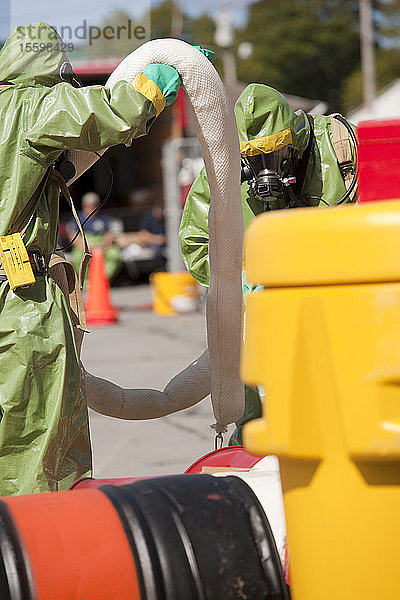 HazMat-Feuerwehrleute richten eine chemische HazMat-Sperre ein  um die Kontamination einzudämmen