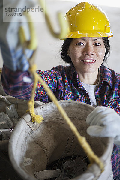 Weiblicher Energietechniker bei der Vorbereitung eines Segeleimers in einer Werkstatt