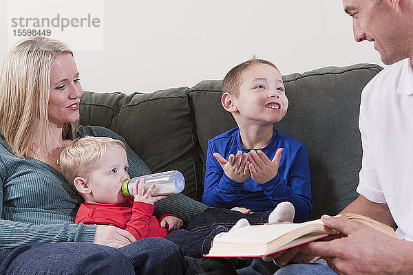 Junge  der das Wort Book in amerikanischer Zeichensprache gebärdet  während er mit seinen Eltern lernt