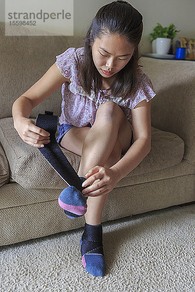 Teenager-Mädchen mit Lernbehinderung stellt Stützen auf ihre Füße