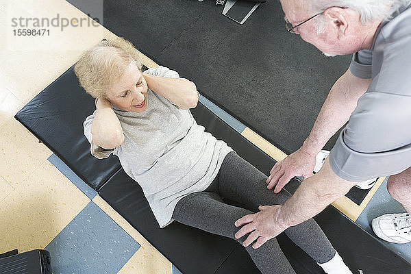 Ein älteres Paar trainiert im Fitnessstudio.