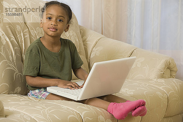 Hispanisches Mädchen arbeitet zu Hause an einem Laptop