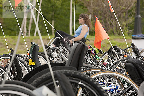Zugängliche Rennräder und eine Frau mit Rückenmarksverletzung im Rollstuhl