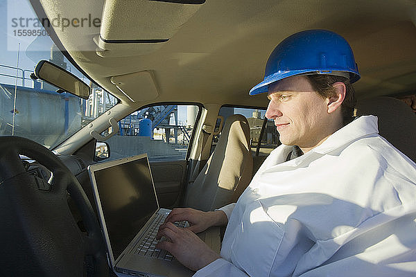 Ingenieur bei der Arbeit an einem Laptop in einem Auto