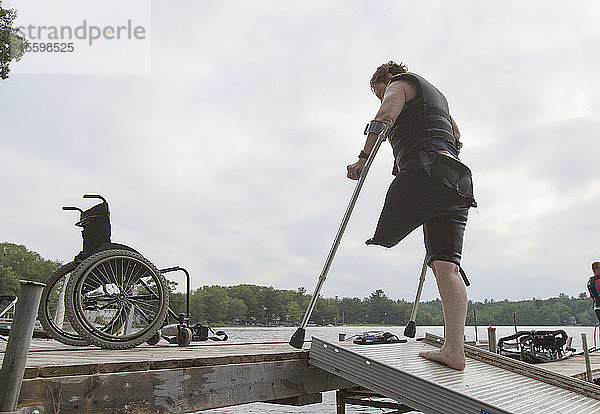 Frau mit einem Bein wartet auf dem Steg  um Wasserski zu fahren