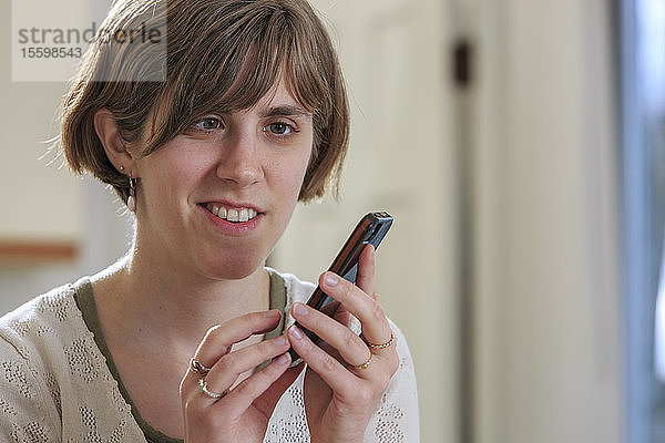 Blinde Frau nutzt Hilfsmittel zum Abhören von Texten auf ihrem Mobiltelefon
