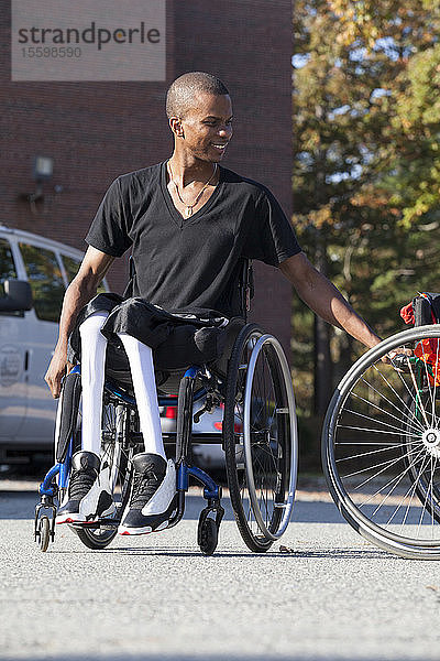 Mann mit Spinaler Meningitis im Rollstuhl beim Einsteigen in sein zugängliches Fahrzeug