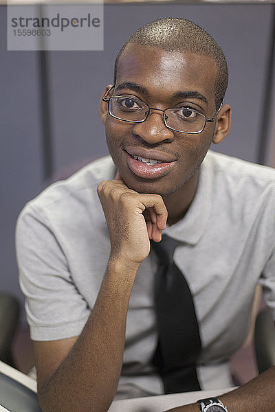 Porträt eines afroamerikanischen Mannes mit Autismus  der in einem Büro arbeitet