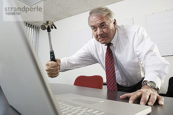 Blick auf einen Geschäftsmann  der versucht  einen Laptop zu treffen.