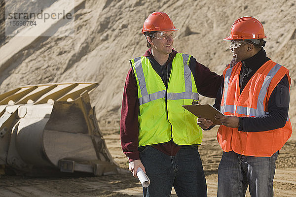 Zwei Ingenieure besprechen sich auf einer Baustelle