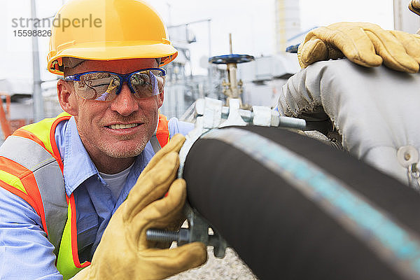 Ingenieur in einem Elektrizitätswerk bei der Prüfung des Schlauchs für die Wasserzufuhr zum Wasserspeichertank