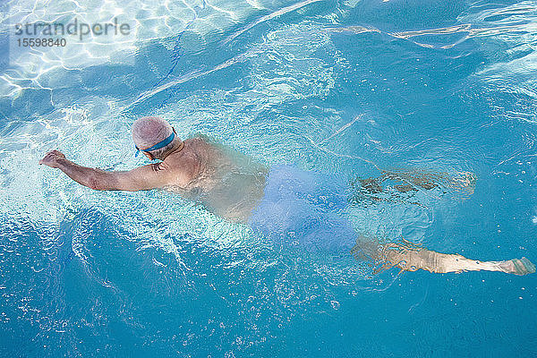 Rückansicht eines älteren Mannes beim Schwimmen in einem Schwimmbad