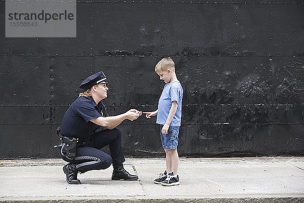 Polizeibeamtin im Gespräch mit einem Jungen.