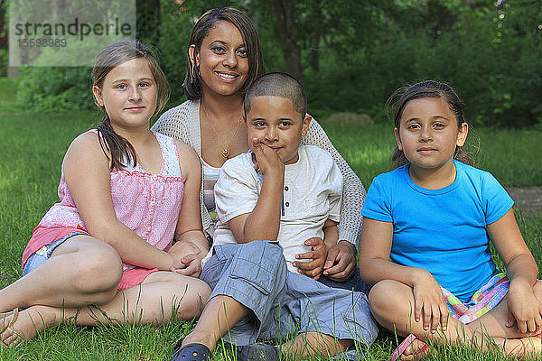 Hispanische Familie mit autistischem Jungen sitzt zusammen im Park