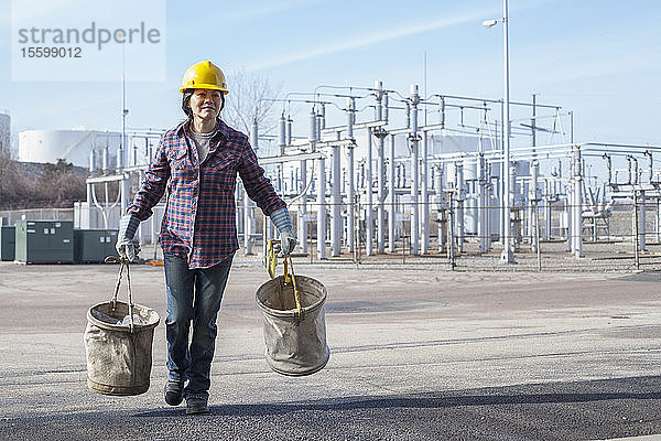 Energietechnikerin mit Segeltuchschaufeln in einem Kraftwerk