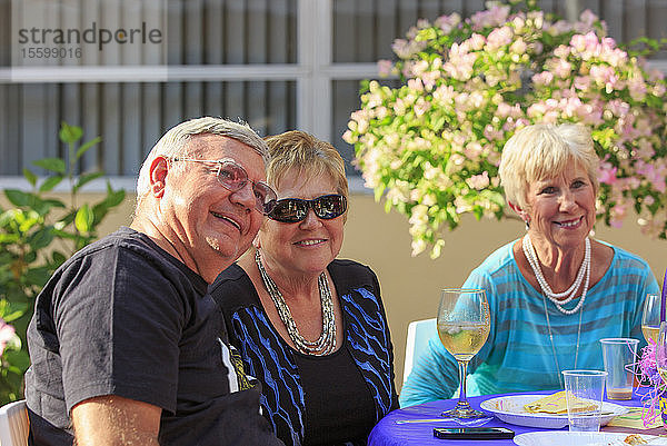 Glückliche Senioren beim Abendessen im Freien