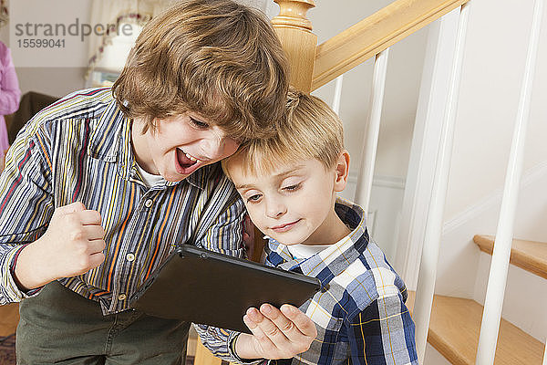 Nahaufnahme von zwei Brüdern  die auf einem digitalen Tablet spielen