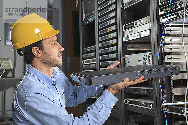 Netzwerktechniker bei der Installation von Kabelgeräten in einem Rack