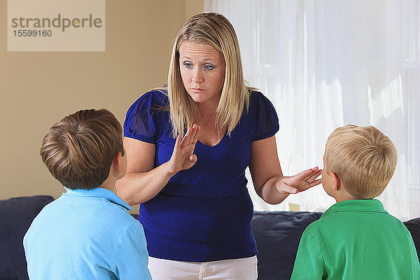 Mutter und Söhne mit Hörbehinderungen gebärden Verhalten in amerikanischer Gebärdensprache