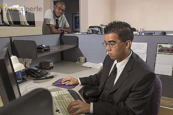 Zwei Männer mit Autismus arbeiten am Computer in einem Büro