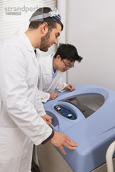 Ingenieurstudenten bei der Arbeit mit einem Bakterienschüttler und einer Kultivierungsmaschine in einem Labor