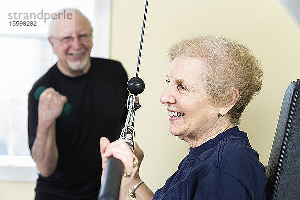 Ein älteres Paar trainiert im Fitnessstudio.