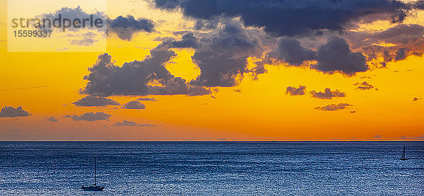 Goldener Sonnenuntergang über dem Meer mit Silhouetten von Segelbooten im Wasser vor Waikiki Beach; Honolulu  Oahu  Hawaii  USA