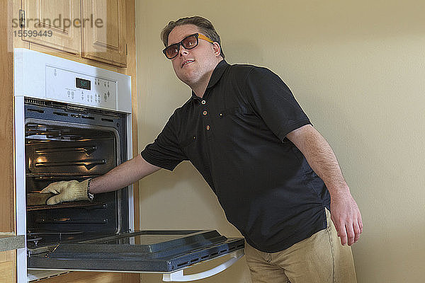Mann mit angeborener Blindheit benutzt den Backofen in seiner Küche