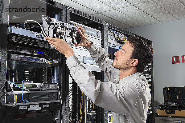 Netzwerktechniker bei der Montage von Koaxial-Switches in einem Gestell