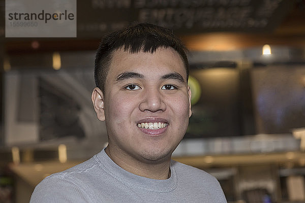 Junger Mann mit Autismus arbeitet in einem Restaurant
