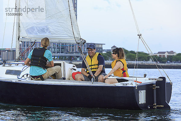 Trainer und Ehepaar mit Sehbehinderung und Diensthund auf einem Boot