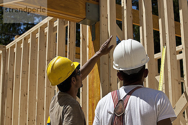 Zimmerleute planen auf einer Baustelle