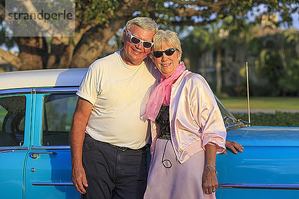 Porträt eines glücklichen älteren Paares vor einem Auto