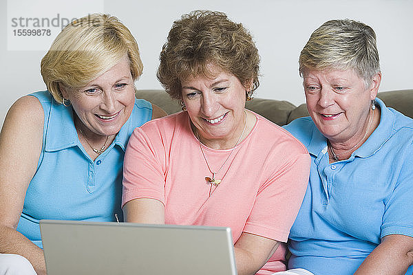 Drei ältere Frauen schauen auf einen Laptop