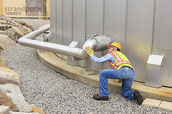 Ingenieur bei der Prüfung der Rohrleitung eines Wasserspeichers in einem Elektrizitätswerk