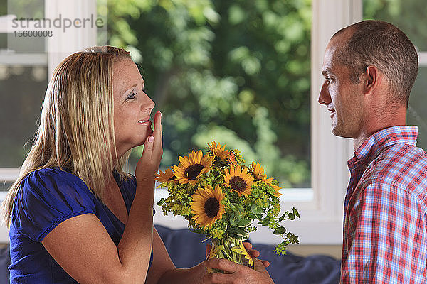Ein Ehemann schenkt seiner Frau Blumen und bedankt sich in amerikanischer Gebärdensprache bei beiden Hörgeschädigten