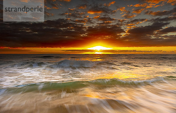 Heller  goldener Sonnenaufgang über Strand und Meer; Kauai  Hawaii  Vereinigte Staaten von Amerika