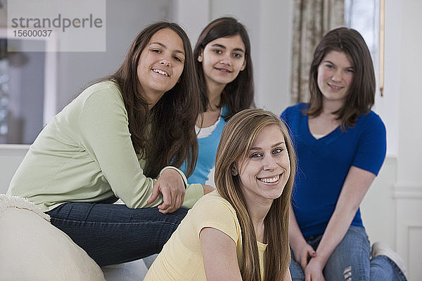 Zwei hispanische Mädchen im Teenageralter lächeln mit ihren Freunden