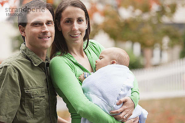 Porträt eines glücklichen Paares  das seinen kleinen Sohn im Arm hält