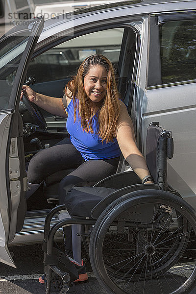 Eine Frau mit einer Rückenmarksverletzung steigt aus ihrem Auto aus