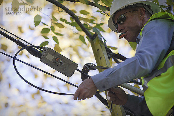 Ingenieur bei der Installation von Geräten an einem Strommast