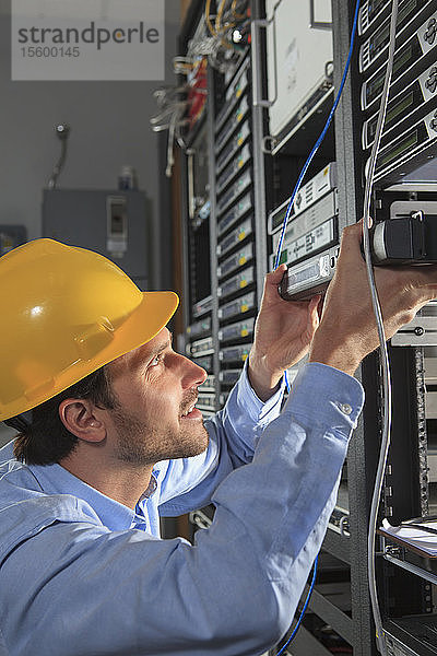 Netzwerktechniker bei der Installation von Kabelgeräten in einem Rack